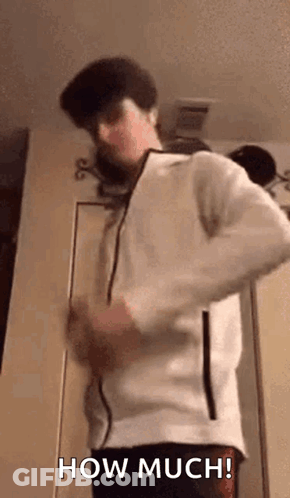A Man In A White Jacket Is Standing In Front Of A Door And Saying How Much . GIF