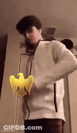 A Man In A White Jacket Is Standing In Front Of A Door With A Yellow Bird On It GIF
