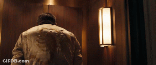 A Man In A White Jacket Is Standing Next To A Light GIF