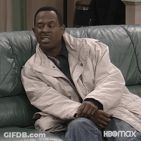 A Man In A White Jacket Sits On A Couch With Hbomax Written On The Bottom Right GIF