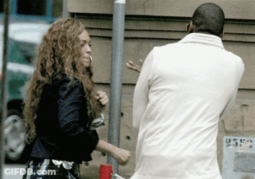 A Man In A White Jacket Stands Next To A Woman In A Black Jacket GIF