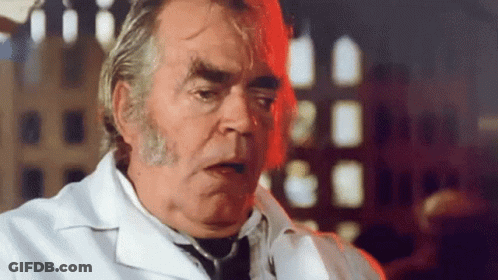 A Man In A White Lab Coat And Tie Is Talking GIF