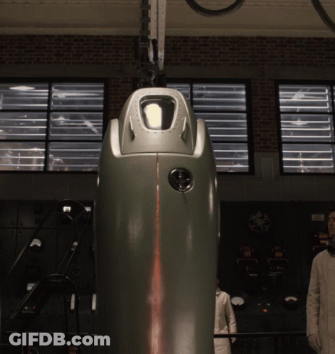 A Man In A White Lab Coat Stands In Front Of A Machine That Says ' A ' On It GIF