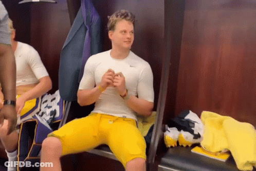 A Man In A White Nike Shirt Sits In A Locker GIF