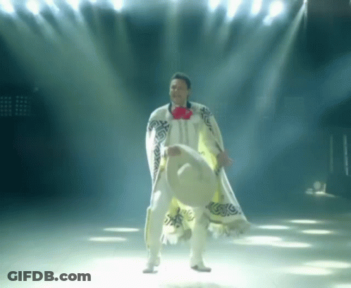 A Man In A White Poncho Holds A Sombrero GIF