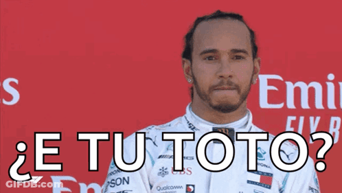 A Man In A White Racing Suit Is Standing In Front Of A Red Emirates Sign GIF