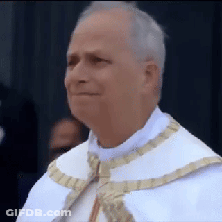 A Man In A White Robe And Gold Trim Is Smiling GIF