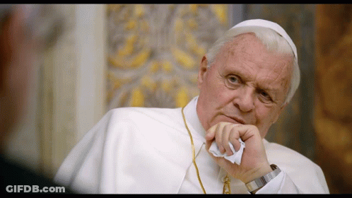 A Man In A White Robe Holds A Piece Of Paper To His Face GIF