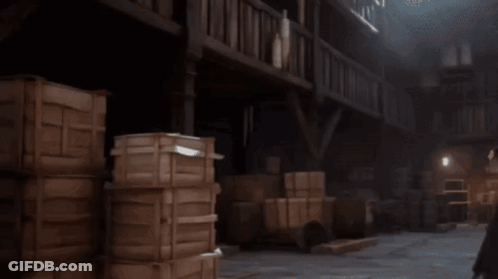 A Man In A White Robe Is Holding A Hammer And Talking To Another Man In A Black Robe GIF
