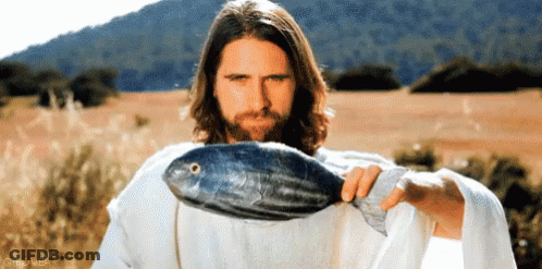 A Man In A White Robe Is Holding A Large Fish In His Hand GIF