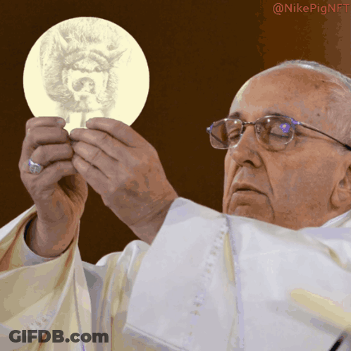 A Man In A White Robe Is Holding A Piece Of Paper With A Picture Of A Dog On It GIF