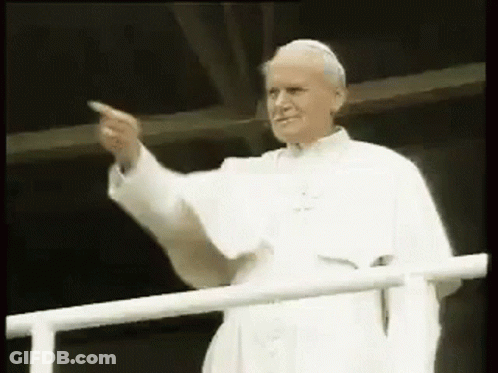 A Man In A White Robe Is Pointing At Something . GIF