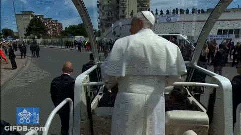 A Man In A White Robe Is Sitting In A Car With A Sign That Says ' Milano ' On It GIF