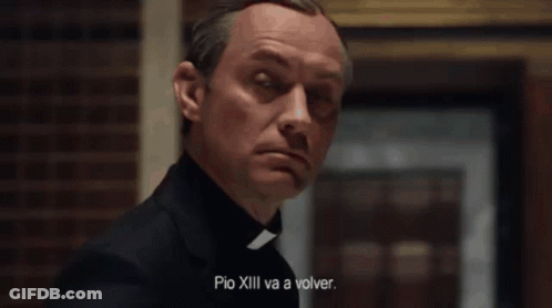 A Man In A White Robe Is Sitting In A Chair With The Words " Quien Es El Papa Ahora " Written On The Bottom GIF
