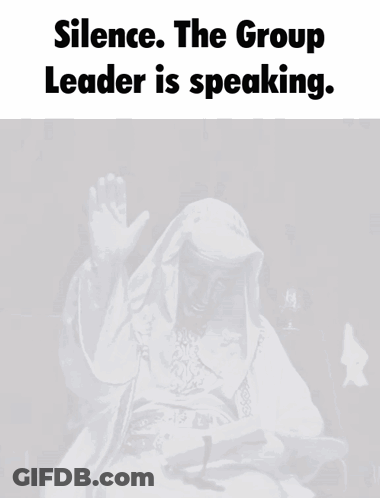 A Man In A White Robe Is Sitting In Front Of A Microphone With The Words " Silence The Group Leader Is Speaking " Above GIF
