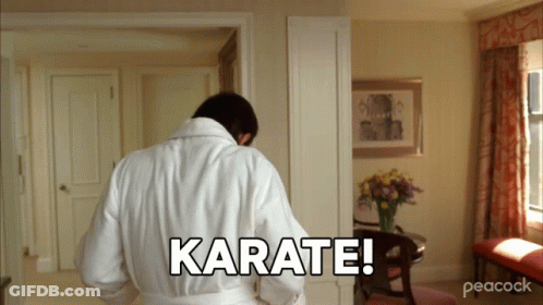 A Man In A White Robe Is Standing In A Room And Says Karate GIF