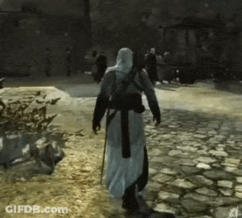 A Man In A White Robe Is Walking Down A Cobblestone Street In A Video Game GIF