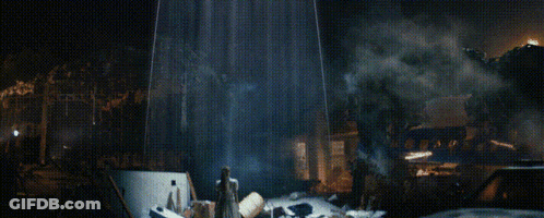 A Man In A White Robe Stands In Front Of A Burning Building GIF