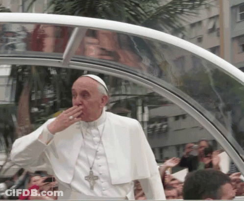 A Man In A White Robe With A Cross Around His Neck Is Covering His Mouth GIF