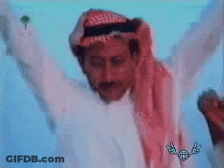 A Man In A White Shirt And A Red Scarf Is Dancing With His Arms Outstretched . GIF