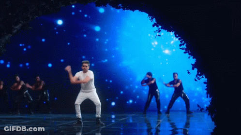 A Man In A White Shirt And Black Pants Is Dancing On A Stage GIF
