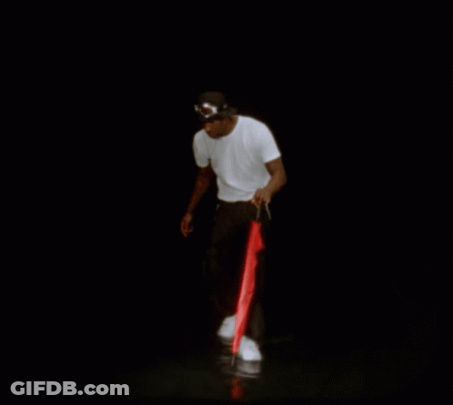 A Man In A White Shirt And Black Pants Is Holding A Red Umbrella GIF