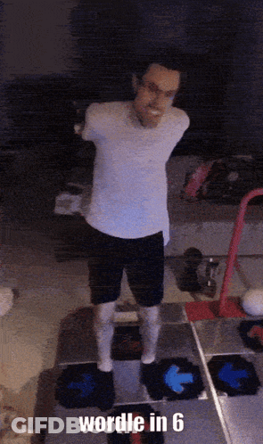 A Man In A White Shirt And Black Shorts Is Standing On A Dance Floor With The Words " Wordle In 6 " Below Him GIF