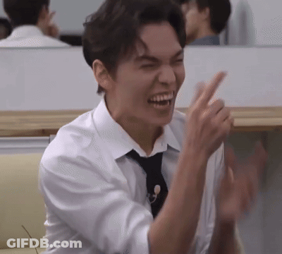 A Man In A White Shirt And Black Tie Is Laughing And Clapping His Hands . GIF
