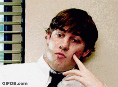A Man In A White Shirt And Black Tie Is Making A Face GIF