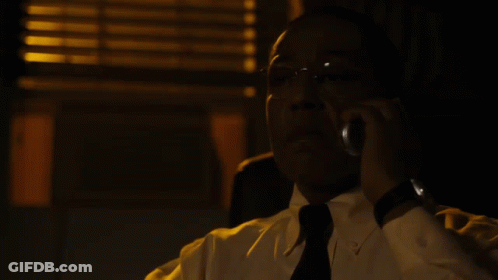 A Man In A White Shirt And Black Tie Talks On A Cell Phone GIF
