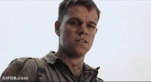 A Man In A White Shirt And Blue Jacket Is Looking At The Camera With A Serious Look On His Face . GIF