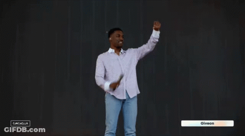 A Man In A White Shirt And Blue Jeans Is Dancing In Front Of A Black Background With The Name Giveon On The Bottom Right GIF