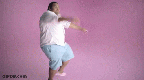 A Man In A White Shirt And Blue Shorts Is Jumping In The Air . GIF