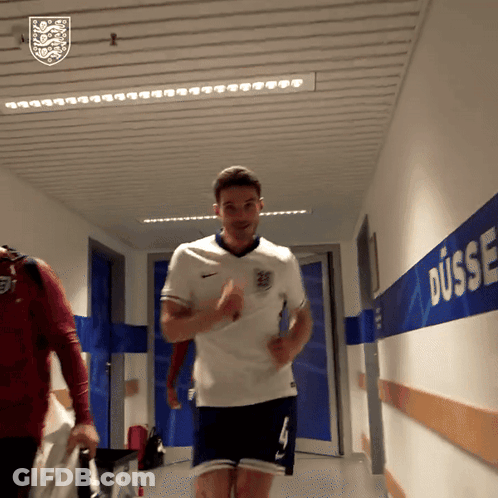 A Man In A White Shirt And Blue Shorts Is Running In A Hallway With Dusse Written On The Wall GIF