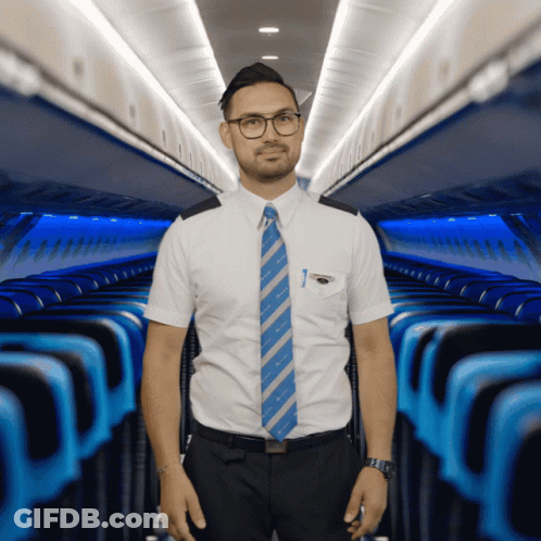 A Man In A White Shirt And Blue Tie Is Standing In A Plane GIF