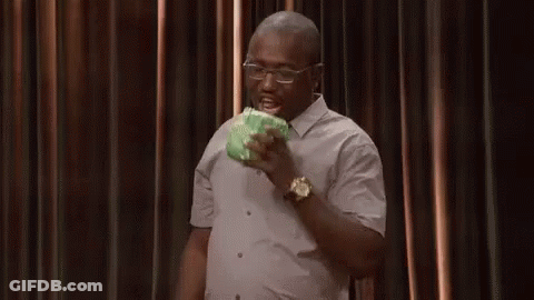 A Man In A White Shirt And Glasses Is Eating A Piece Of Cabbage . GIF