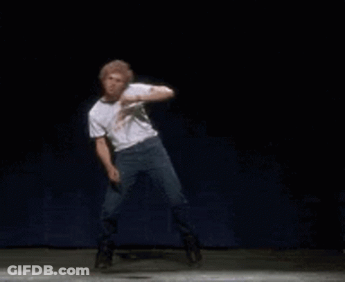 A Man In A White Shirt And Jeans Is Dancing On A Stage . GIF