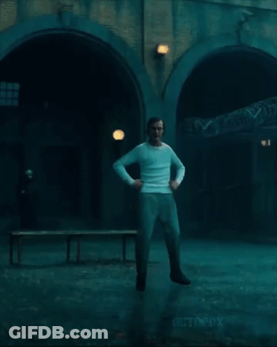 Man In White Shirt And Jeans Jumping In Dark Room GIF