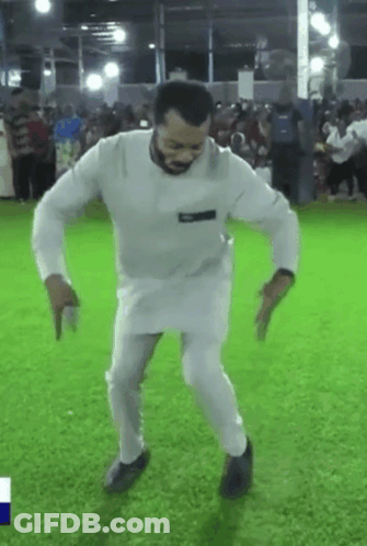 A Man In A White Shirt And Pants Is Dancing On A Field . GIF