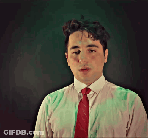 A Man In A White Shirt And Red Tie Is Looking Down GIF