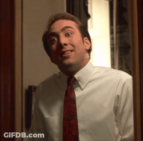 A Man In A White Shirt And Red Tie Looks At Himself In The Mirror GIF
