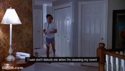 A Man In A White Shirt And Shorts Is Cleaning His Room GIF