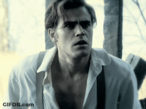 A Man In A White Shirt And Suspenders Is Looking At Something GIF