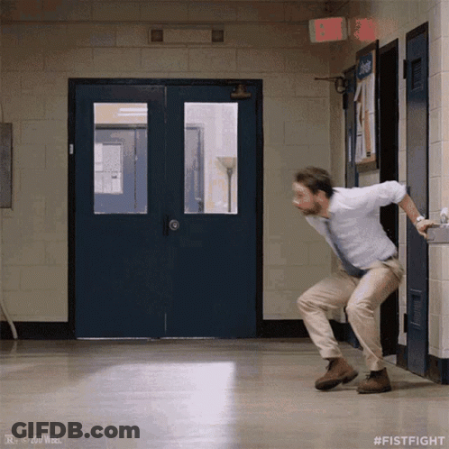 A Man In A White Shirt And Tie Is Dancing In A Hallway With # Fistfight On The Bottom GIF