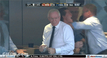 A Man In A White Shirt And Tie Is Dancing In Front Of A Screen That Says NFL Cubs GIF