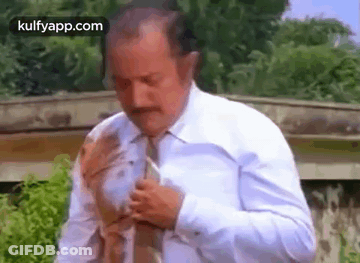 A Man In A White Shirt And Tie Is Getting Ready To Go Out . GIF