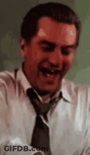 A Man In A White Shirt And Tie Is Laughing While Holding A Piece Of Paper . GIF