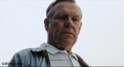 A Man In A White Shirt And Tie Is Looking At The Camera With A Serious Look On His Face . GIF