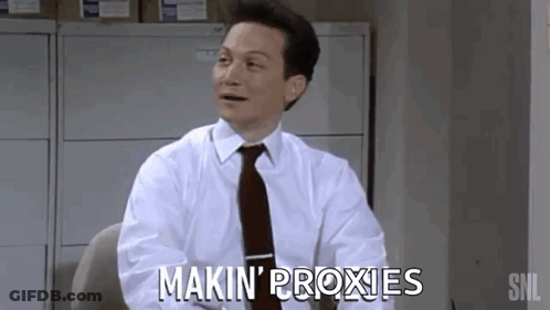 A Man In A White Shirt And Tie Is Sitting At A Desk And Saying Makin ' Proxies GIF