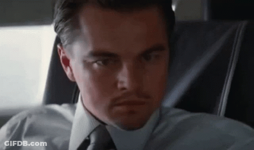A Man In A White Shirt And Tie Is Sitting In A Car . GIF